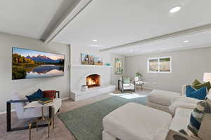 Living area featuring beamed ceiling, carpet floors, a brick fireplace, and recessed lighting