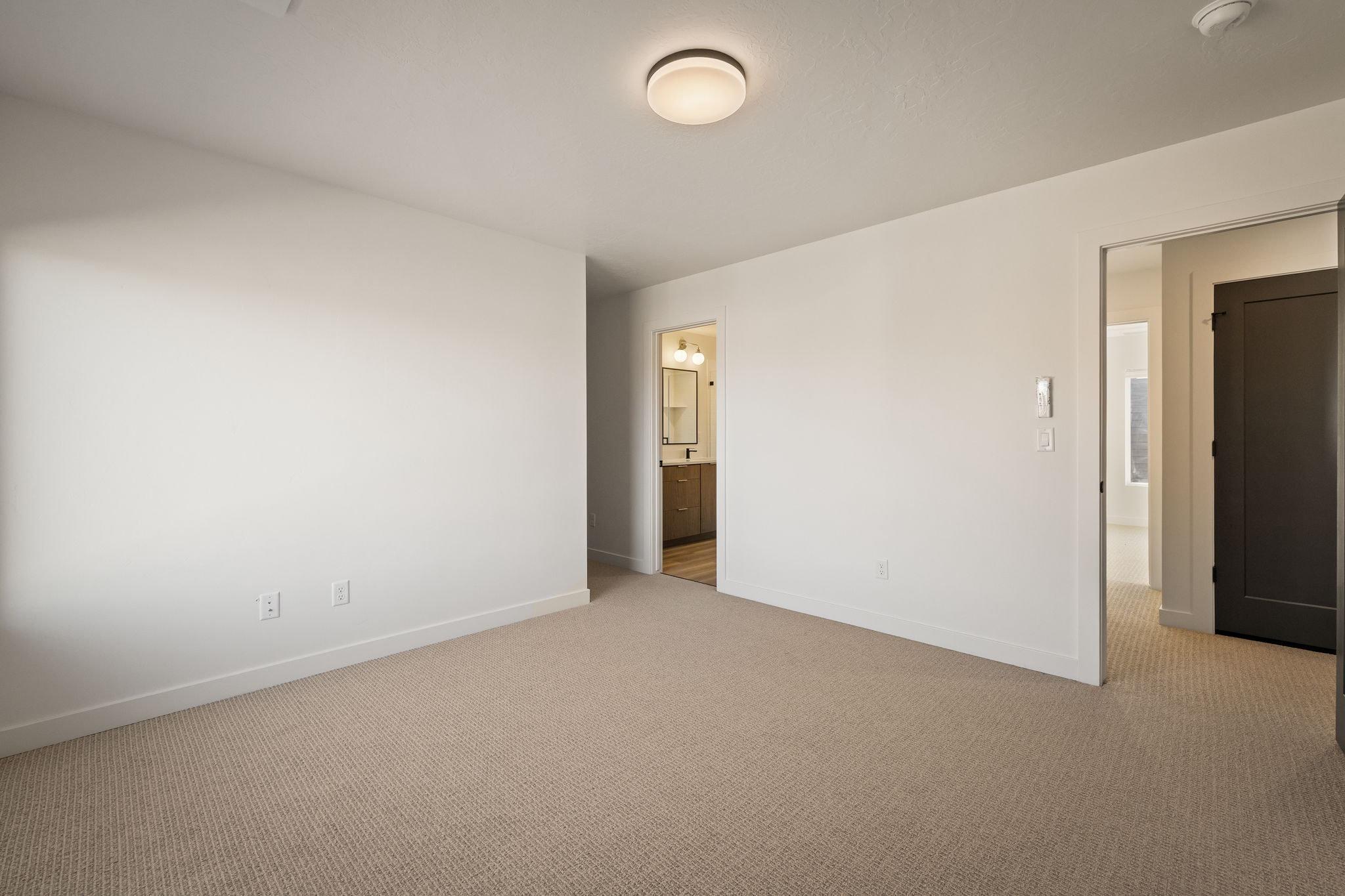 Unfurnished bedroom with carpet flooring and ensuite bathroom