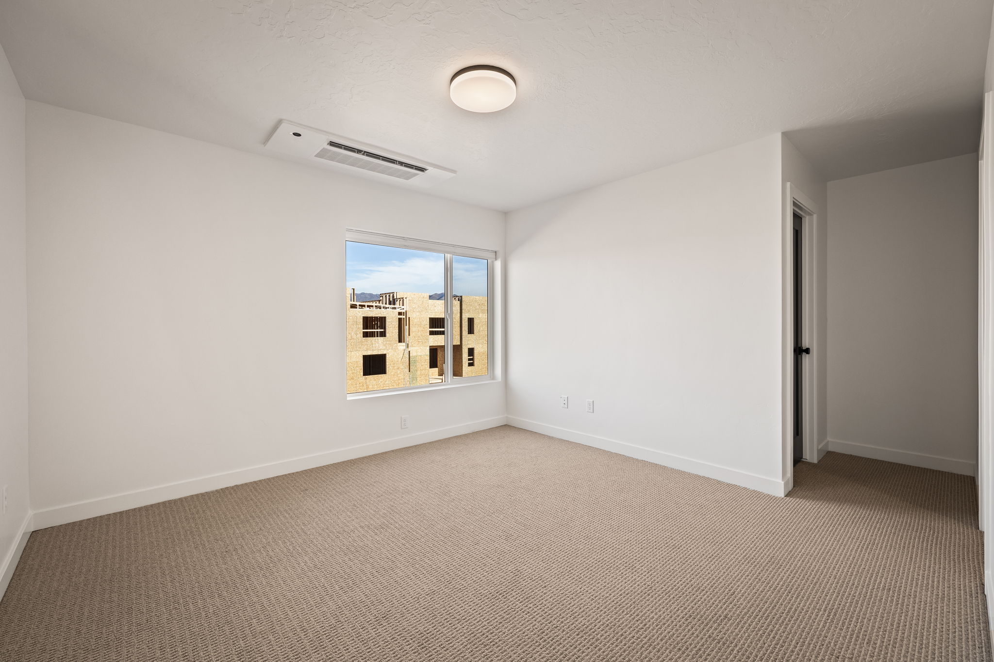 Carpeted spare room with cooling unit and baseboards