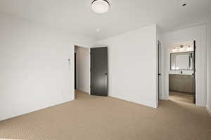 Unfurnished bedroom featuring carpet flooring and ensuite bathroom