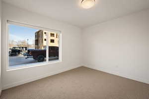 Spare room featuring carpet and baseboards