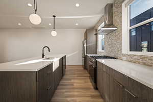 Kitchen featuring modern cabinets, stainless steel appliances, backsplash, hanging light fixtures, and dark wood finished floors