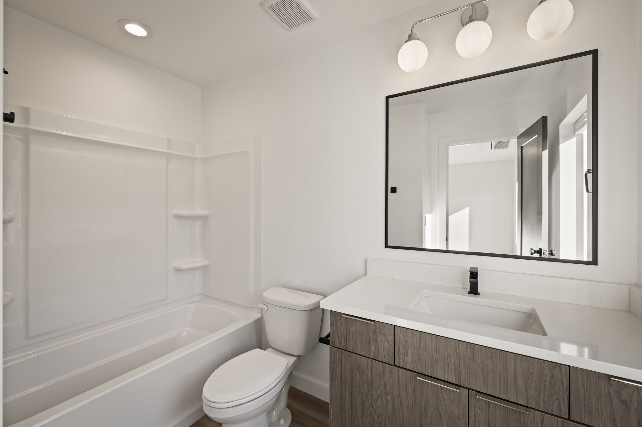 Bathroom with vanity, washtub / shower combination, and recessed lighting