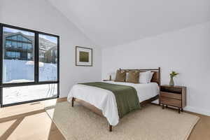 Bedroom featuring light wood-style flooring and vaulted ceiling