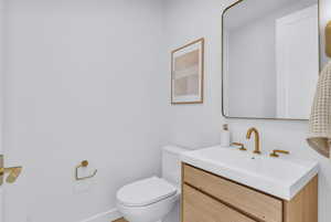 Half bath featuring vanity and toilet