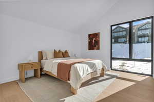 Bedroom featuring light wood-type flooring and vaulted ceiling