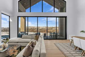 Living area with a mountain view, wood finished floors, lofted ceiling, and plenty of natural light