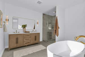 Bathroom with a soaking tub, double vanity, a shower stall, and light tile patterned floors