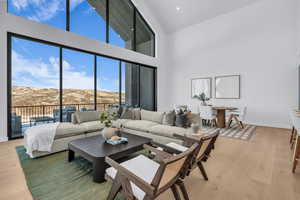 Living room with light wood-style flooring, a mountain view, and vaulted ceiling