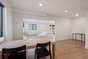 Dining room with light wood-style flooring and recessed lighting