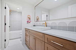 Full bath featuring vanity,  shower combination, recessed lighting, light tile patterned floors, and tasteful backsplash