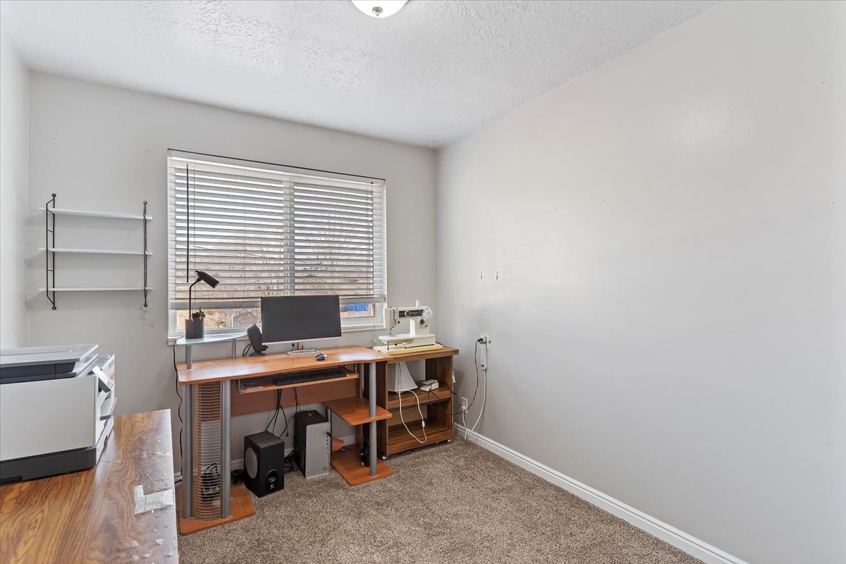 Office featuring light carpet and a textured ceiling
