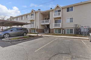 View of complex with uncovered parking and stairs