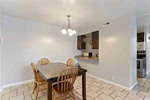 Dining area featuring suspended lighting and baseboards