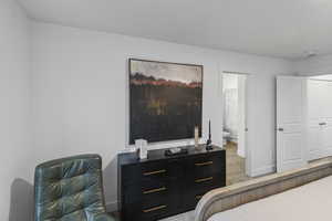 Bedroom featuring baseboards and connected bathroom