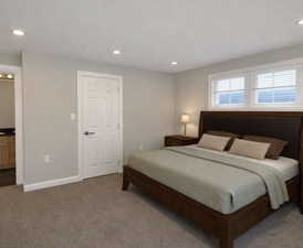 Bedroom featuring carpet flooring, recessed lighting, and ensuite bath