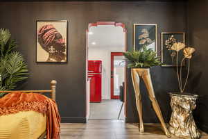 Bedroom with freestanding refrigerator, wood finished floors, and recessed lighting