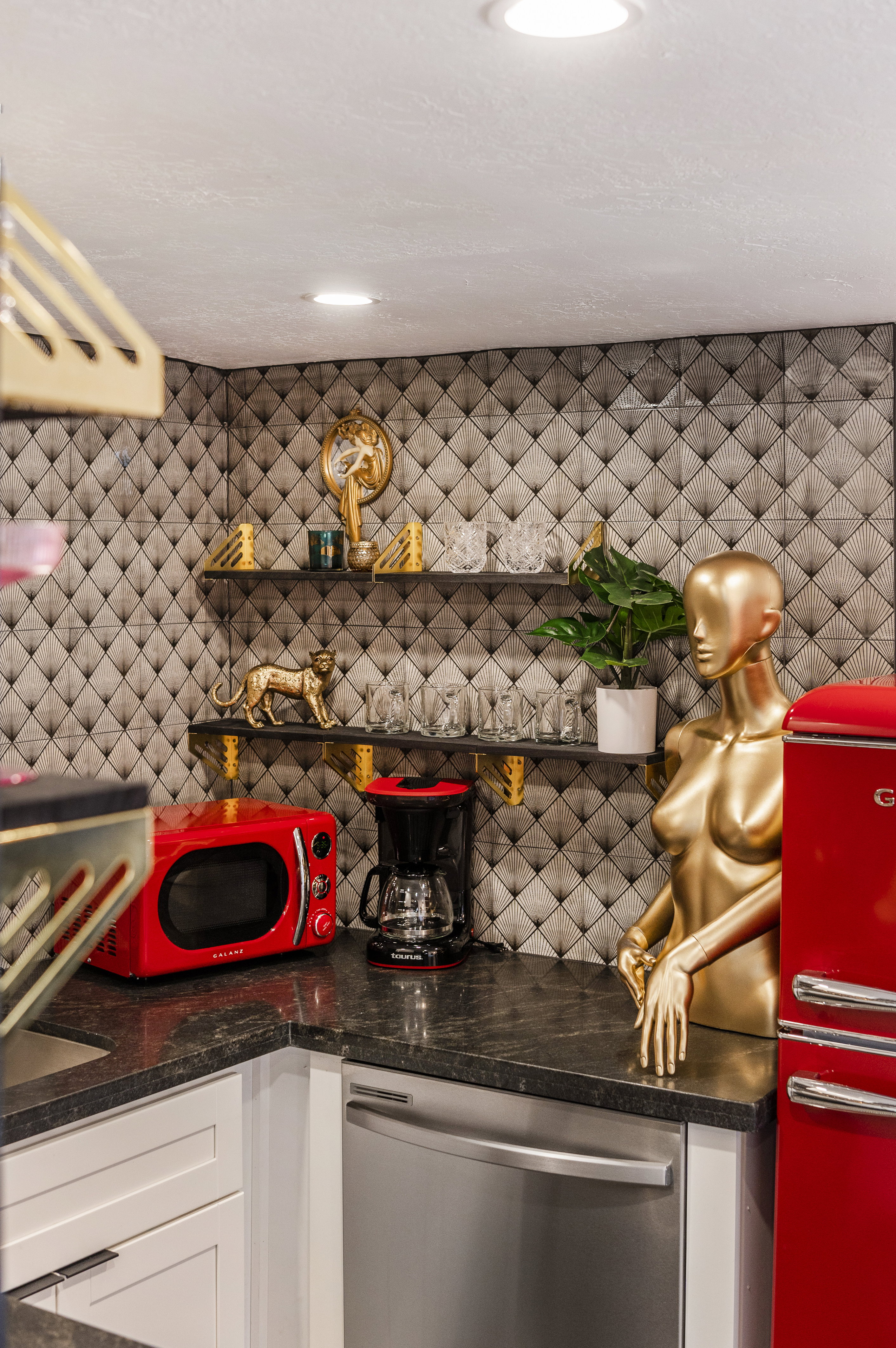 Kitchen with white cabinetry, stainless steel dishwasher, tasteful backsplash, and dark stone countertops