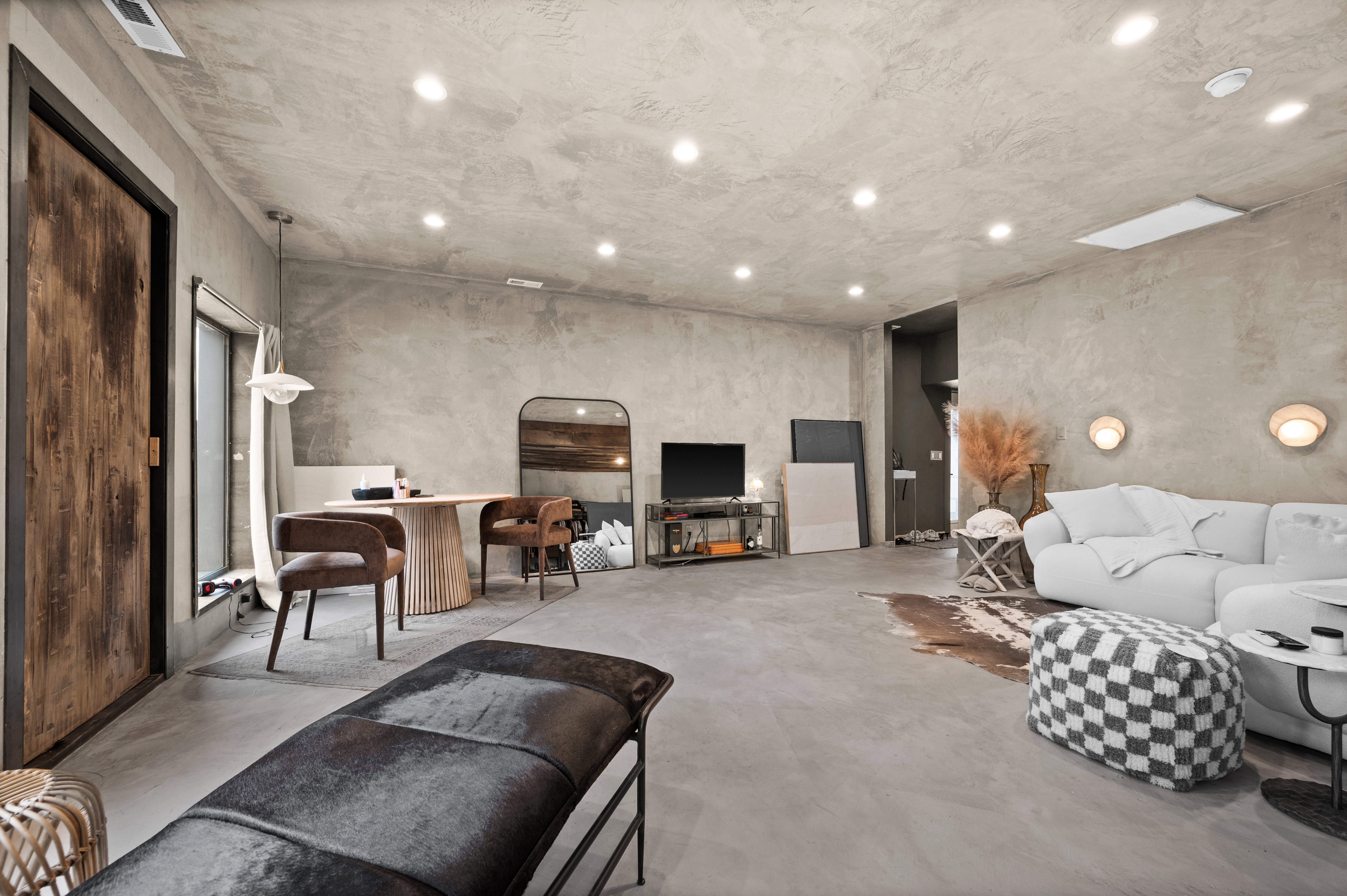 Living area with concrete flooring and recessed lighting