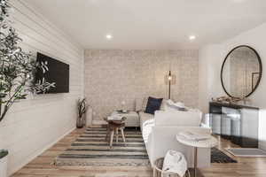 Living area with wood finished floors and recessed lighting