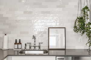 Kitchen view of dark stone counters and decorative backsplash