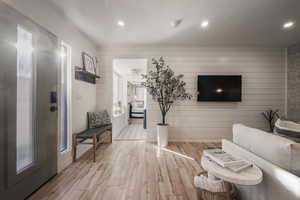 Living room featuring wooden walls, wood finished floors, and recessed lighting