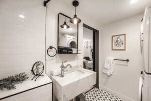 Bathroom featuring stacked washer and clothes dryer, recessed lighting, vanity, and tile patterned floors