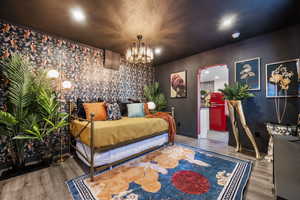 Bedroom featuring wood finished floors and hanging lights