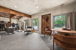 Living area featuring concrete floors, plenty of natural light, recessed lighting, and beam ceiling
