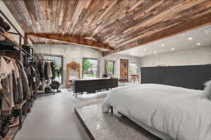 Bedroom with finished concrete flooring and vaulted ceiling