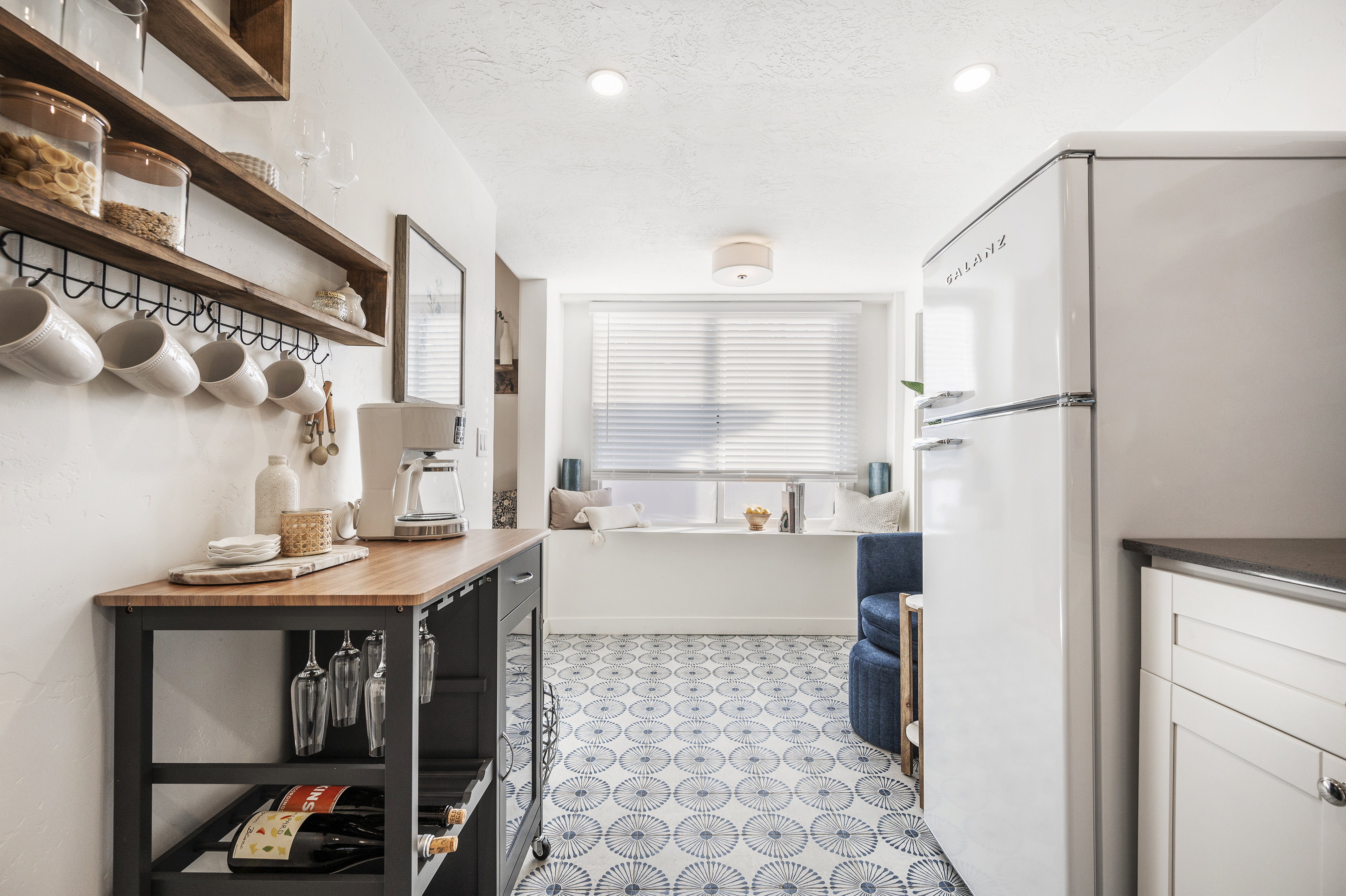 Kitchen featuring freestanding refrigerator, open shelves, light flooring, a textured ceiling, and recessed lighting