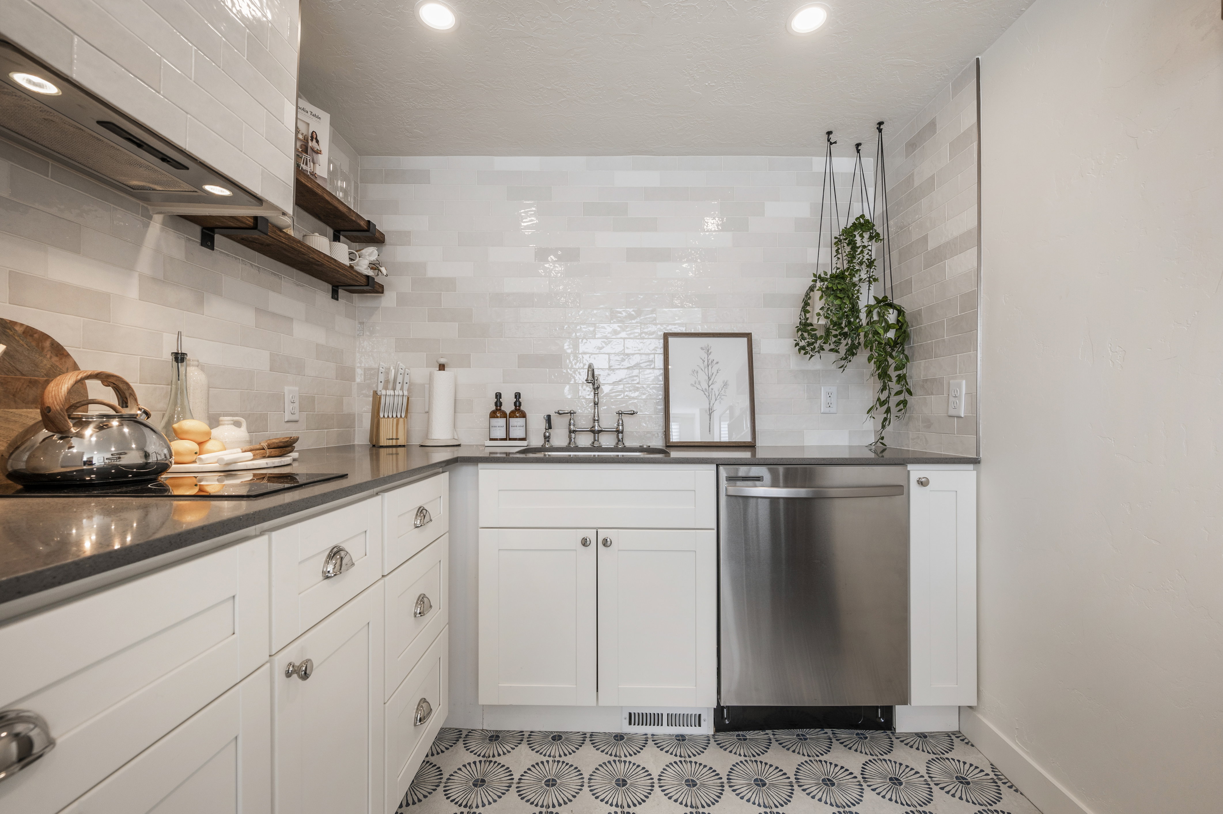 Kitchen with open shelves, white cabinets, dishwasher, dark stone counters, and recessed lighting