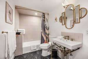 Bathroom featuring shower / tub combo with curtain and toilet