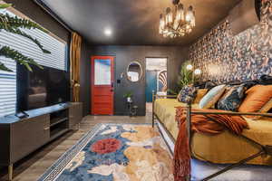Bedroom featuring suspended lighting and wood finished floors