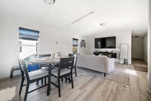 Dining room with lofted ceiling and light wood-style floors