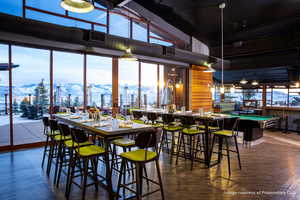 Dining space with a mountain view, high vaulted ceiling, pool table, and dark wood-style flooring