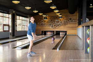 Game room with bowling, wood walls, and vaulted ceiling
