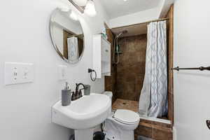 Bathroom featuring a stall shower and a textured ceiling