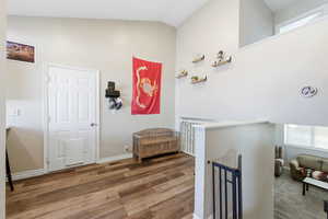 Entryway featuring healthy amount of natural light, lofted ceiling, and wood finished floors