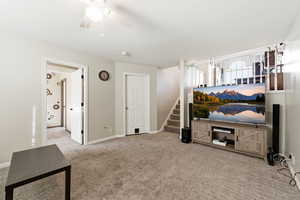 Living area featuring light carpet and a ceiling fan