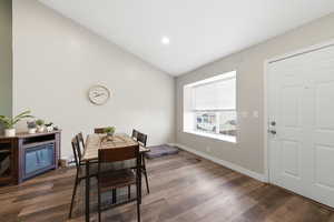 Dining space featuring vaulted ceiling, dark wood finished floors, and recessed lighting