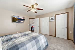 Bedroom with light colored carpet, a closet, and ceiling fan