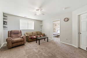 Living area featuring ceiling fan and light carpet