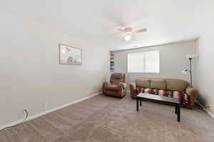 Living room with ceiling fan and carpet