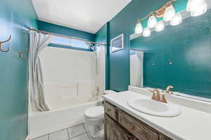 Bathroom with shower / bath combo, vanity, and light tile patterned floors