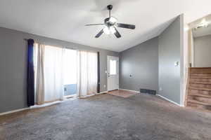 Unfurnished living room with ceiling fan, carpet flooring, and lofted ceiling