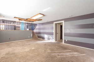 Unfurnished room with carpet, wallpapered walls, and a textured ceiling