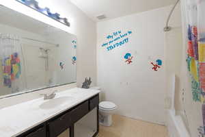 Bathroom with light floors, vanity, and shower / bath combination with curtain
