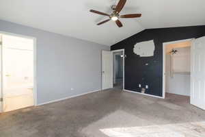 Unfurnished bedroom with a spacious closet, carpet flooring, a ceiling fan, and ensuite bathroom