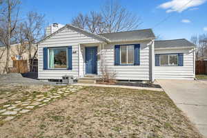 View of front of home featuring a chimney and roof with shingles